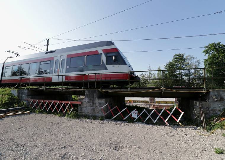 Ein Triebwagen überquert kurz vor der Streckensperre die alte Stahlbrücke